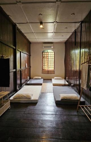 a room with four beds in it with a window at Thai Traditional Home in Bangkok