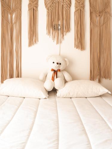 a teddy bear sitting on top of a bed at L'École Villa Nature in Abrantes