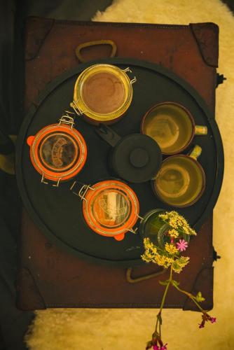 a table with different colored pots and a vase with a flower at Devon Belltents - South Milton in Hope Cove