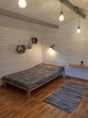 a bedroom with a bed in a room with a rug at Cozy house for your holidays in Bernāti