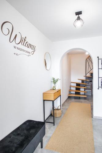 a living room with a black couch and stairs at Cozy mountain house - Coolówka pod Babią Górą in Zubrzyca Dolna