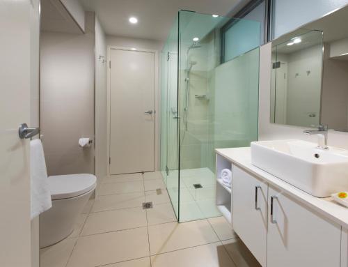 a bathroom with a glass shower and a sink at Whitsunday Apartments in Hamilton Island