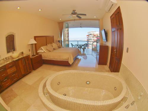 een badkamer met een bad in het midden van een kamer bij Mondavi in Puerto Vallarta