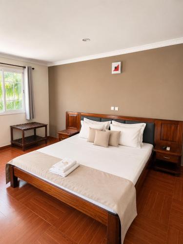 a bedroom with a large bed with white pillows at Hôtel Sofia Bellevue in Antsohihy