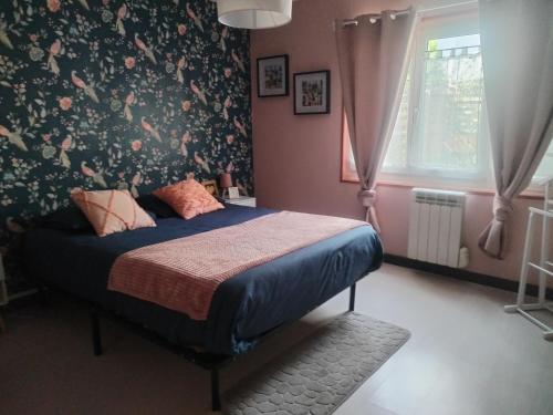 a bedroom with a bed with floral wallpaper at Le Nichoir de Lesmont in Lesmont