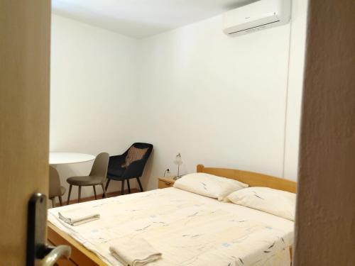a bedroom with a bed and two chairs in it at inKorcula in Korčula