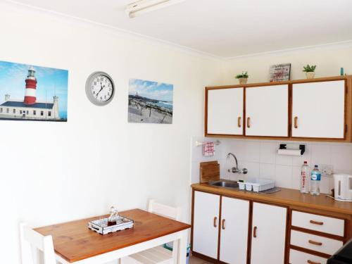 a kitchen with a sink and a lighthouse on the wall at The Goose Nest in Struisbaai