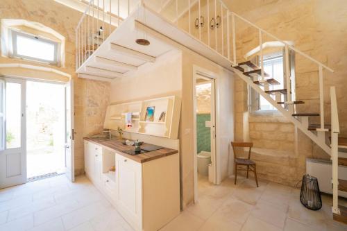 a bathroom with a sink and a staircase at HISTORIA - Dimore in Corte in Borgagne