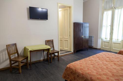 a hotel room with a bed and a table and chairs at Hotel Reina in Buenos Aires