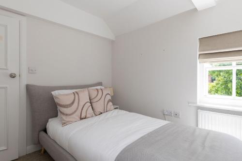 a white bedroom with a bed with a pillow at NEW - Herricks by The Butler Collection in Arundel
