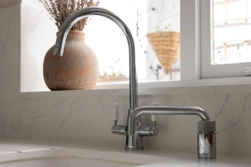 a kitchen sink with a faucet next to a window at NEW - Herricks by The Butler Collection in Arundel