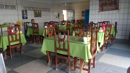 une salle à manger avec des tables et des chaises vertes dans l'établissement Pousada Araguaia, à Agrestina