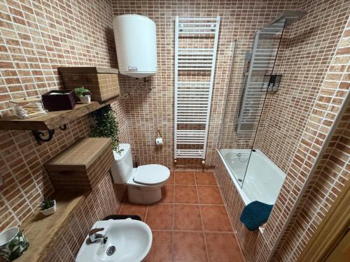 a bathroom with a toilet and a sink and a tub at La Sima del Anillo in Cardaño de Abajo