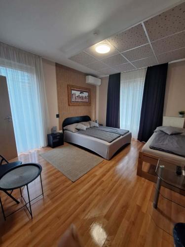 a large bedroom with two beds and a wooden floor at Velvet Motel in Hegyeshalom