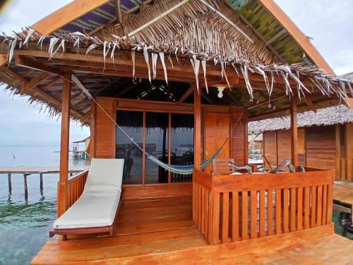 a resort boat with a hammock on the water at Angelfish Guest House Raja Ampat in Besir