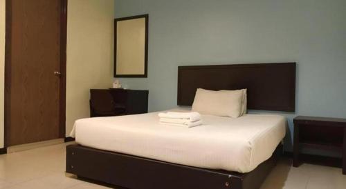 a bedroom with a large bed with white sheets at BB Motel in Alor Setar