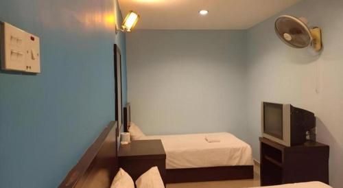 a small room with two beds and a television at BB Motel in Alor Setar