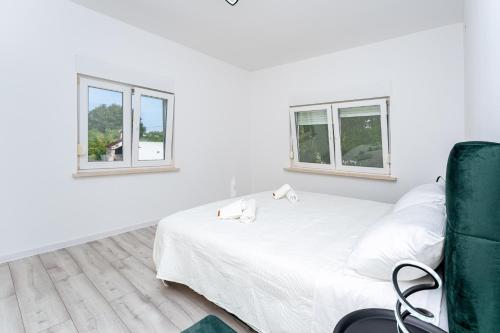 a white room with a bed and two windows at Villa Sunshine in Pridraga