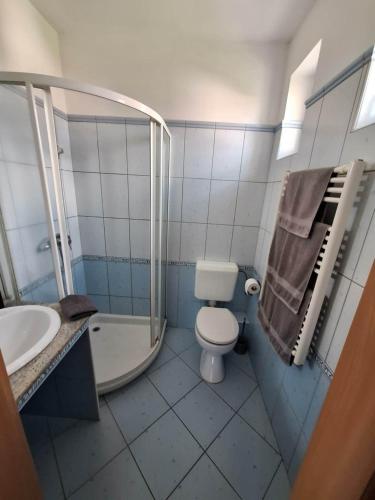 a bathroom with a toilet and a sink and a shower at Velvet Motel in Hegyeshalom