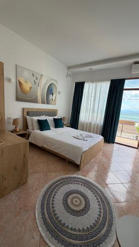a bedroom with a large bed and a large window at Iart Residence in Shirokë