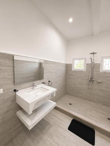 a bathroom with a large white sink and a tub at Hôtel Sofia Bellevue in Antsohihy