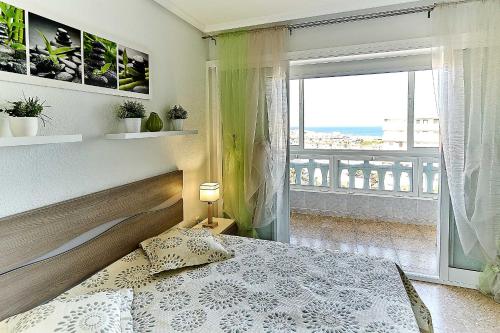 a bedroom with a bed and a large window at Espanhouse Vera Torreblanca in Torrevieja