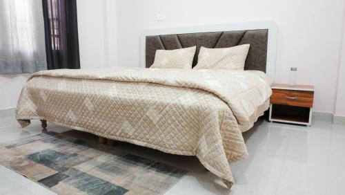 a bedroom with a large bed and a night stand at Dimora Homes, Bir in Bīr