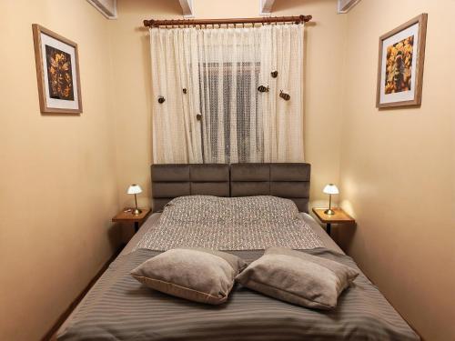 a bed with two pillows in a bedroom with two lamps at Pszczeli Ogród - dom na wyłączność z jacuzzi ze świeżą wodą in Dęba Koliszowy