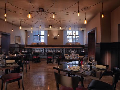 a dining room with tables and chairs and lights at Malmaison Hotel Leeds in Leeds