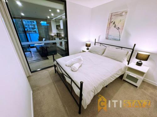 a bedroom with a bed with a white comforter at Braddon Base in The Midnight, Heated Pool & Sauna in Braddon