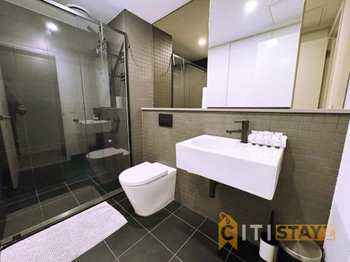 a bathroom with a toilet and a sink and a shower at Braddon Base in The Midnight, Heated Pool & Sauna in Braddon
