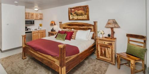 a bedroom with a large bed and a kitchen at Mat-Su Resort in Wasilla