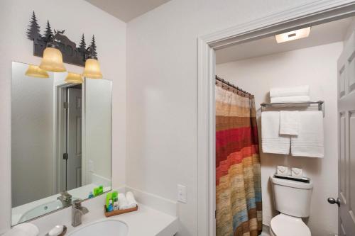 W łazience znajduje się umywalka, toaleta i lustro. w obiekcie Mat-Su Resort w mieście Wasilla
