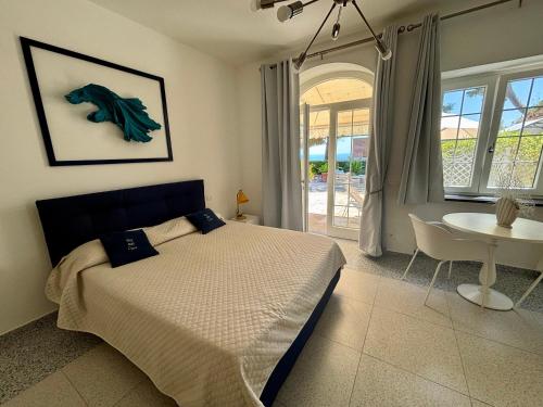 a bedroom with a bed and a table and a window at To Be Capri Sea view Rooms in Capri