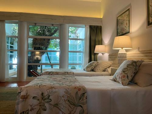 a bedroom with two beds and a large window at Casa Do Foral in Rio Maior