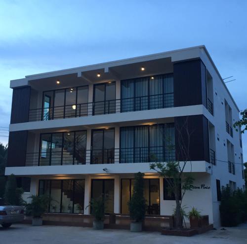 a black building with windows and a parking lot at Ma Room Place Sukhothai Resort in Sukhothai
