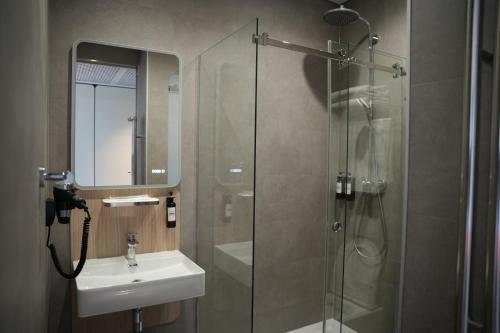 a bathroom with a glass shower and a sink at Keruen inn Karaganda in Karagandy