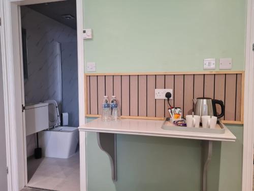 a kitchen counter with bottles of water on it at Moorside Hotel and Cafe in Stoupe Brow