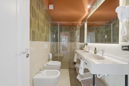 a bathroom with two sinks and a toilet and a shower at Agroturizem Cialda in Shkallnur