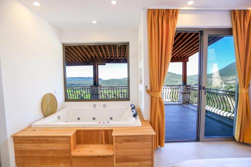 a bathroom with a large tub and a balcony at Villa Sydney in Kaş