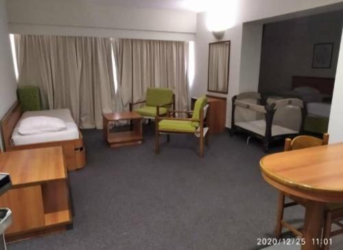 a living room with a room with a bed and a table at Hotel Cristina Suites in Puerto La Cruz