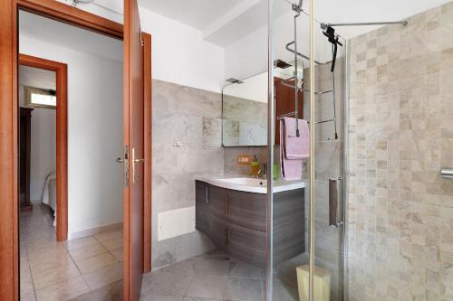 a bathroom with a sink and a glass shower at Casa Beccari in Cala Liberotto