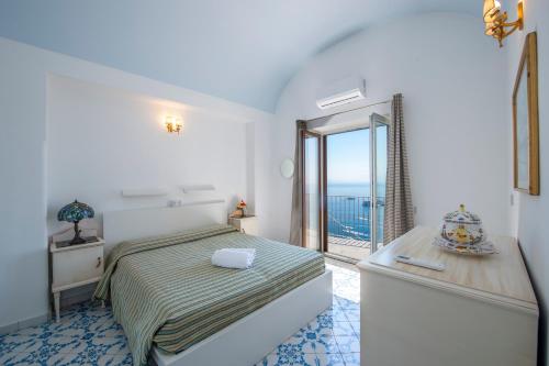 a bedroom with a bed and a view of the ocean at Villa Alba - Amalfi Coast in Amalfi