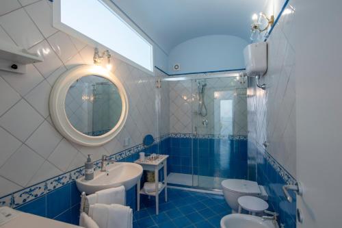a blue and white bathroom with a sink and a mirror at Villa Alba - Amalfi Coast in Amalfi