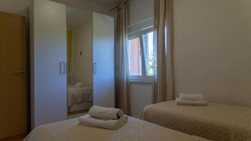 a bedroom with two beds and a mirror at Villa Emanuela by Villas Guide in Grubine