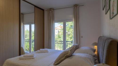 a bedroom with two beds and a large window at Villa Emanuela by Villas Guide in Grubine