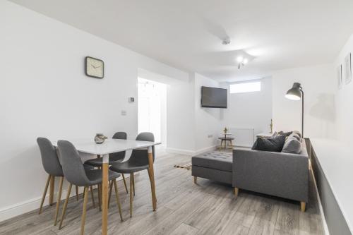 a living room with a table and a couch at Charming Two Bed - Two Bath Apt (25KM) in Headingley