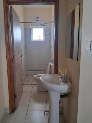 a bathroom with a sink and a toilet at Cozy 2 BR with 3 Beds, AC & Hot Shower at Buxton Point Apartments Off RG Road Gate A in Mombasa