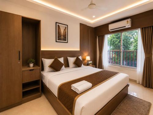 a bedroom with a large bed and a window at The Kingsway Suites in Nagpur