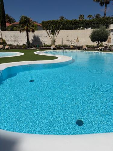 a large swimming pool with blue water at Lovely Apartament Taidia in Maspalomas